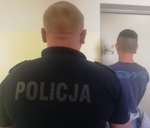 policjant prowadzi zatrzymanegp