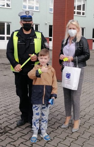 policjant przed szkołą podstawową podczas akcji ,, Bezpieczna droga do szkoły&quot;