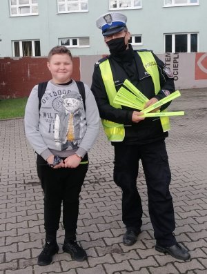 policjant podczas akcji profilaktycznej ,, Bezpieczna droga do szkoły&quot;
