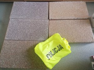 nielegalne papierosy zabezpieczone przez policjantów, na nich kamizelka z napisem policja