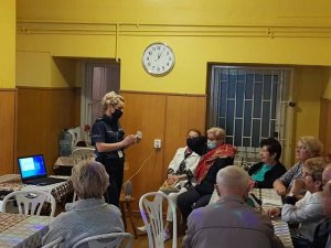 Dzielnicowa podczas spotkania z seniorami omawia metody działania oszustów