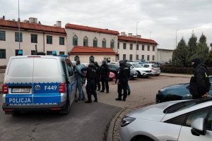 policjanci zakładają zatrzymanemu kajdanki
