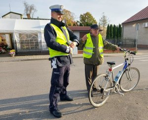 policjant stojący razem z rowerzystom, który ma założoną kamizelkę odblaskową