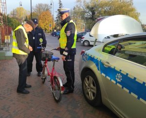 policjanci podczas przekazywania kamizelki odblaskowej rowerzyście