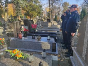 Delegacja kadry kierowniczej Komendy Miejskiej Policji w Piotrkowie Trybunalskim stoja przy grobie generała Henryka Wardęskiego na cmentarzu rzymskokatolickim w Piotrkowie Trybunalskim