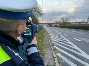 policjant ruchu drogowego podczas pomiaru prędkości na drodze