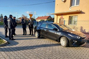 Uczestniczący w przekazaniu radiowozu, z prawej strony widoczny radiowóz nieoznakowany