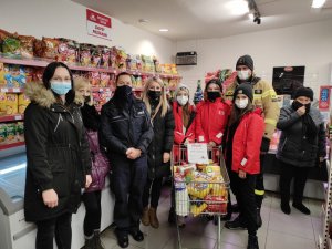 policjantka, naczelnik OSP Rozprza wraz z radną gminy Niechcicę Jolą Krupą oraz druchnami KDP Niechcice w sklepie przy wózku pełnym darów