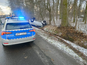 toyota verso znajdująca się w rowie, pojazd leży na dachu, obok policyjny radiowóz