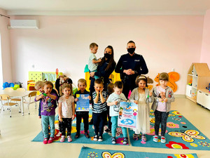 policjanci razem z dziećmi w sali przedszkolnej