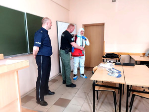 student w założonym kombinezonie z wyposażeniem technika kryminalistyki