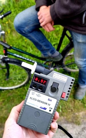 urządzenie do pomiaru prędkości, w tle widoczny ręce i nogi mężczyzny siedzącego na rowerze