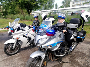 dzieci z grupy przedszkolnej siedzą na policyjnych motocyklach
