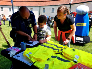 policjant podczas odciskania linii papilarnych, w tle Komisarz Błysk