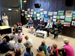 na zdjęciu Komendant Malanowski czyta bajkę przedszkolakom na terenie piotrkowskiej Mediateki