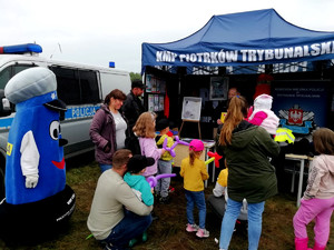 odwiedzający przy namiocie policyjnym, z lewej strony Komisarz Błysk