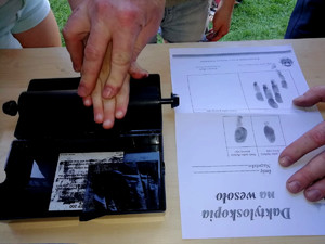 policjant odbija dziecku linie papilarne na artach Daktyloskopia na wesoło