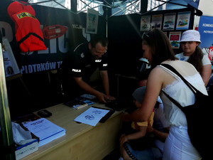 policjant w policyjnym namiocie rozmawia z odwiedzającymi o bezpieczeństwie