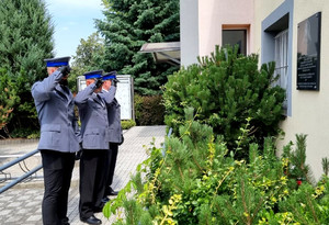 policjanci salutują oddając hołd przed tablicą pamiątkową w Czarnocinie
