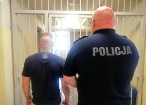 policjant prowadzi zatrzymanego