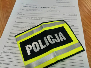 opaska z napisem Policja na formularzy zawiadomienia o zaginięciu osoby