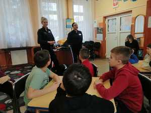 policjantki na terenie Szkoły Podstawowej nr 13 w Piotrkowie Trybunalskim przeprowadzają pogadankę o bezpieczeństwie