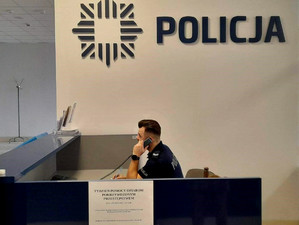 policjant pełni dyżur telefoniczny podczas Tygodnia Pomocy Osobom Pokrzywdzonym Przestępstwem