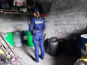 policjantka wykonuje czynności na miejscu odnalezenia kradzionego paliwa