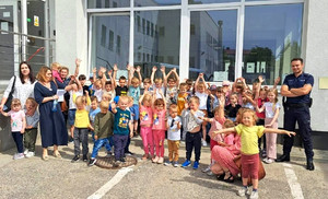 zdjęcie grupowe na dziedzińcu piotrkowskiej jednostki Policji z grupą przedszkolną z Ręczna