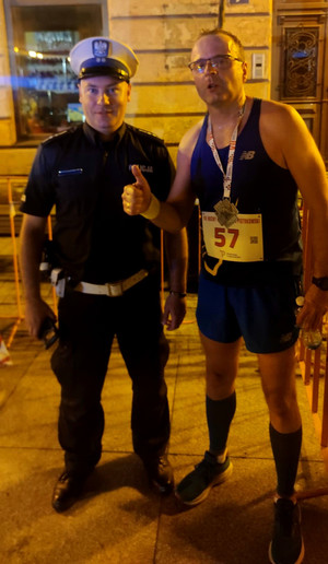 Zastępca Komendanta Miejskiego Policji w Piotrkowie Trybunalskim jako uczestnik Piotrkowskiego Nocnego Półmaratonu, na zdjęciu wspólnie z zabezpieczającym wydarzenie zastępcą Naczelnika Wydziału Ruchu Drogowego Komendy Miejskiej Policji w Piotrkowie Trybunalskim