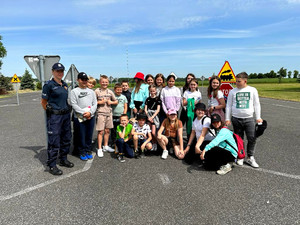 policjantka na zdjęciu z grupą uczniów zdających egzamin na kartę rowerową