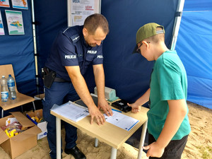 Policjant zbierający odbitki linii papilarnych.
