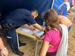 Policjant pobierający odbitki linii papilarnych.