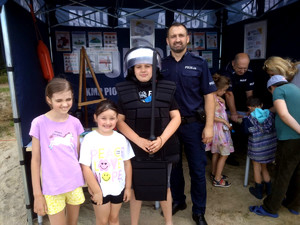 Policjanci z dziećmi przy policyjnym namiocie.
