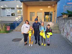 Na zdjęciu widać policjantkę wraz z trójką dzieci oraz matką przy jednej ze szkół podstawowych.