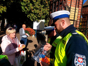 Policjanci podczas przekazywania odblasków w rejonie cmentarzy.