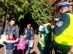 Policjanci podczas przekazywania odblasków w rejonie cmentarzy.