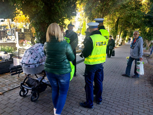 Policjanci podczas przekazywania odblasków w rejonie cmentarzy.