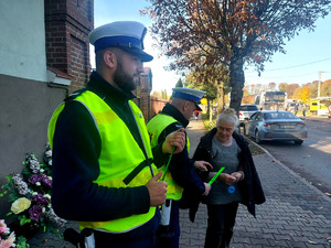 Policjanci podczas przekazywania odblasków w rejonie cmentarzy.