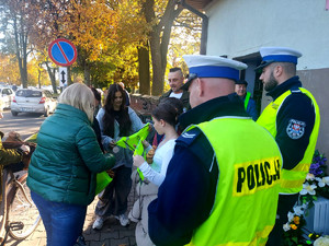 Policjanci podczas przekazywania odblasków w rejonie cmentarzy.