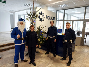 Policjanci z mikołajem przy choince.