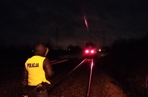 policjant na miejscu zdarzenia, w tle widoczny pociąg.
