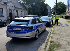 Policjanci podczas kontroli zaparkowanego pojazdu.