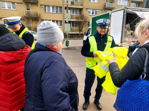 Policjanci podczas przekazywania seniorom elementy odblaskowe.