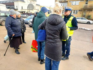 Policjanci podczas przekazywania seniorom elementy odblaskowe.