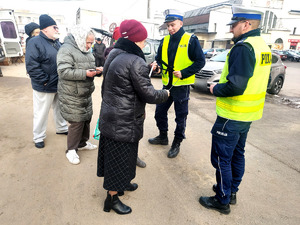 Policjanci podczas przekazywania seniorom elementy odblaskowe.