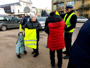 Policjanci podczas przekazywania seniorom elementy odblaskowe.