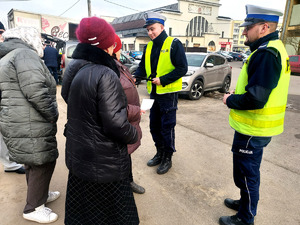 Policjanci podczas przekazywania seniorom elementy odblaskowe.