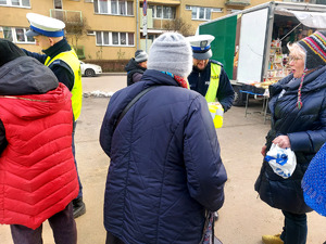 Policjanci podczas przekazywania seniorom elementy odblaskowe.