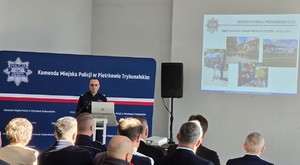 Komendant Miejski Policji w Piotrkowie Trybunalskim wraz z zaproszonymi gośćmi w auli Komendy Miejskiej Policji podczas odprawy rocznej.